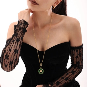 Elegant gold stainless steel necklace featuring a green snowflake zircon pendant on a model