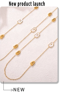 Detail of a long gold chain necklace with mother of pearl horseshoe pendants and bean charms