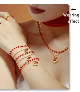 Dettaglio del set collana e bracciale a doppio strato con ciondoli a cappello di Natale