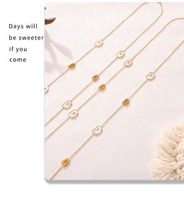 Detail of long layered necklace featuring golden beans and white mother of pearl inlays