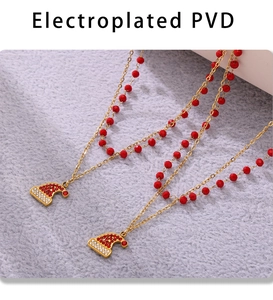 Dettaglio della collana placcata in oro PVD con pietre rosse e ciondolo natalizio