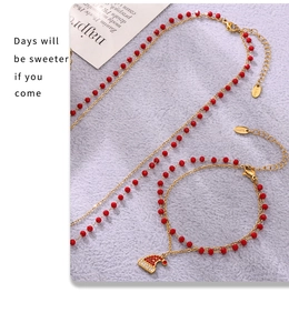 Dettaglio macro del set festivo collana e bracciale in acciaio dorato con ciondolo a cappello