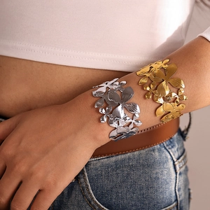 Gros plan détaillé de bracelets fleurs ajourés avec finitions polies en or et argent