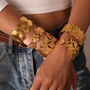 Gros plan détaillé d'un bracelet manchette en or 18 carats avec motifs de feuilles de ginkgo