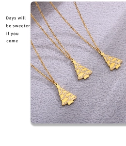Close-up of three gold Christmas tree pendants with inlaid zircons on a gray plush base