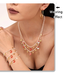 Close-up of a model wearing a double-layer pearl necklace with festive Christmas charms