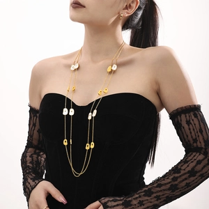 Elegant long gold-tone necklace with natural white sea shell pendants for layered styling