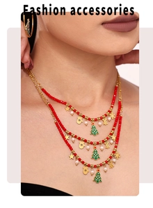 Close-up of layered Christmas necklace with enamel trees, stars and red beads on a model
