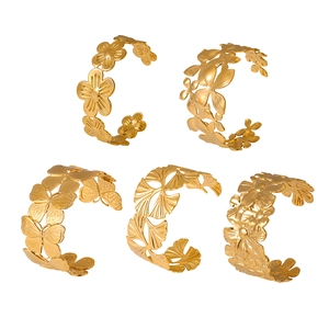 Lot de cinq bracelets ouverts évidés en or 18 carats avec fleurs et papillons