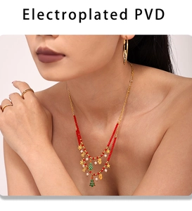 Detail of PVD plated layered Christmas necklace with enamel tree and snowflake pendants