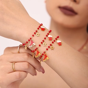 Red beaded Christmas charm bracelet with gold enamel skates and cocoa pendants