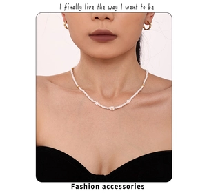 Détail d'un collier de perles marguerite et de boucles d'oreilles dorées sur un mannequin