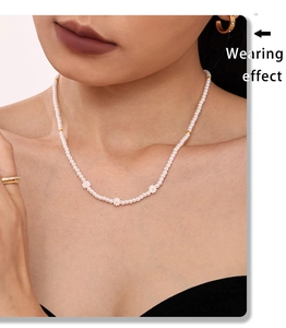 Gros plan du collier de perles avec des fleurs de marguerites et perles dorées