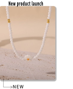 Gros plan du collier de perles blanches avec pendentif marguerite sur pierre claire