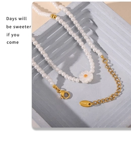 Détail du collier de perles avec pendentif marguerite et fermoir en acier inoxydable poli