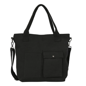 Minimalist black canvas tote bag with adjustable shoulder strap and utility pockets