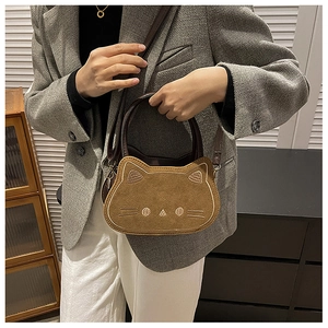 Modell mit brauner Wildleder-Handtasche in Katzenform und weißen Stickereien