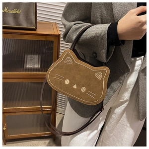 Detailed embroidery on a brown cat-shaped suede crossbody bag with versatile straps