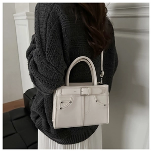 Detailed back view of white PU leather handbag with denim pocket stitching and metal studs