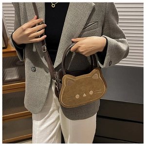 Detailansicht der braunen Handtasche in Katzenform mit Stickerei und rundem Griff