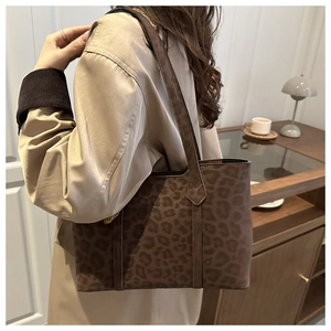Side view of a vintage leopard print tote bag on a model wearing a beige trench coat