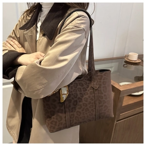Sac fourre-tout à motif léopard marron porté par un mannequin en manteau d'automne