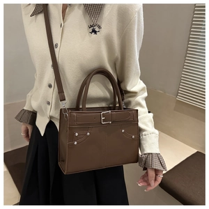 Vue détaillée du sac à main vintage marron foncé avec boucles et clous argentés