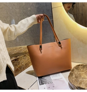 Detailansicht einer braunen Leder-Tragetasche mit FASHION-Schriftzug in edlem Ambiente