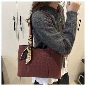 Détail du sac cabas bordeaux avec relief léopard et foulard en soie baroque