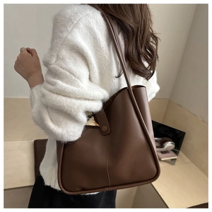 Detailed side view of large brown faux leather tote bag with stylish floral silk scarf