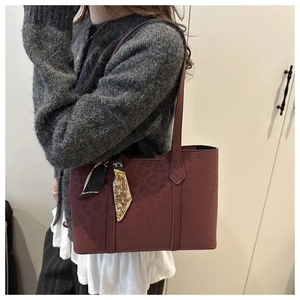 Detail of burgundy leopard print tote bag with decorative silk scarf on shoulder strap