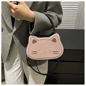 Close-up of a pink cat-shaped crossbody bag with gold embroidery and brown handles