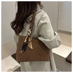 Sac cabas marron en daim à imprimé léopard avec foulard en soie porté par mannequin