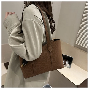 Brown leopard print tote bag with decorative scarf shown on shoulder for daily commute