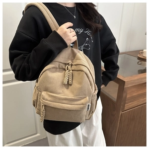 Close-up of beige corduroy mini backpack featuring ribbed texture and Fashion label detail