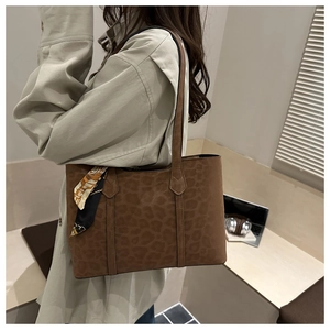 Gros plan d'un sac cabas marron à imprimé léopard avec foulard en soie décoratif