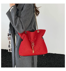 Detailansicht der roten Beuteltasche aus Wolle mit goldener Logo-Kette und Quastendetail