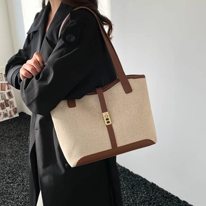 Retro canvas and leather patchwork tote bag with gold lock buckle shown on model