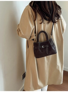 Détail du sac bandoulière vintage marron foncé avec coutures contrastées blanches