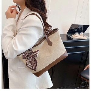 Canvas tote bag with brown leather trim and scarf detail styled for office commute
