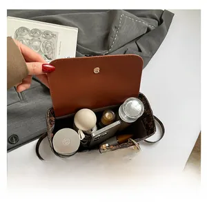 Internal view of brown letter print handbag showing capacity for phone and umbrella