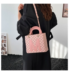 Détail du sac à bandoulière rose clair avec logo M en 3D et imprimé monogramme