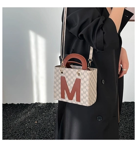 Détail du sac bandoulière avec monogramme M marron et finitions en métal doré chic