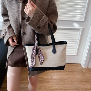 Minimalist canvas tote bag with black leather trim and decorative silk scarf for women