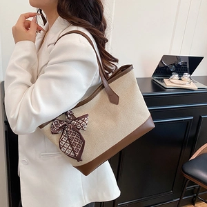 Women's chic beige woven tote bag with brown leather trim and decorative printed bow
