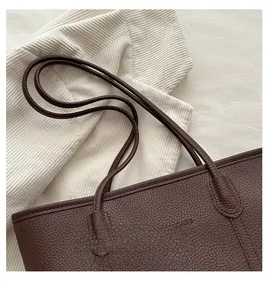 Detail of dark brown lychee grain leather tote bag with soft round shoulder straps