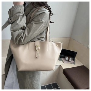 Dettaglio borsa tote in pelle beige con fibbia dorata e cuciture di alta qualità