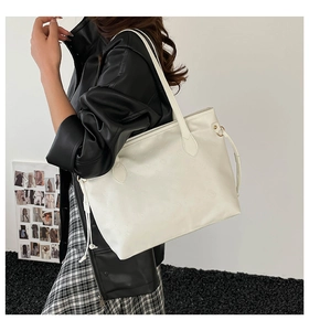 Detailed close-up of white tote bag with embossed pattern texture worn by a model