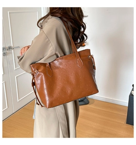 Brown tote bag with embossed cartoon pattern shown on shoulder for sizing and fit