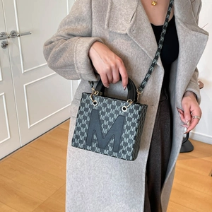 Sac à main gris brodé avec grand logo M et large bandoulière porté avec manteau laine